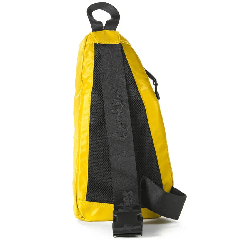 Yellow traveler sling bag with black mesh back panel and adjustable strap featuring "Cookies" branding.